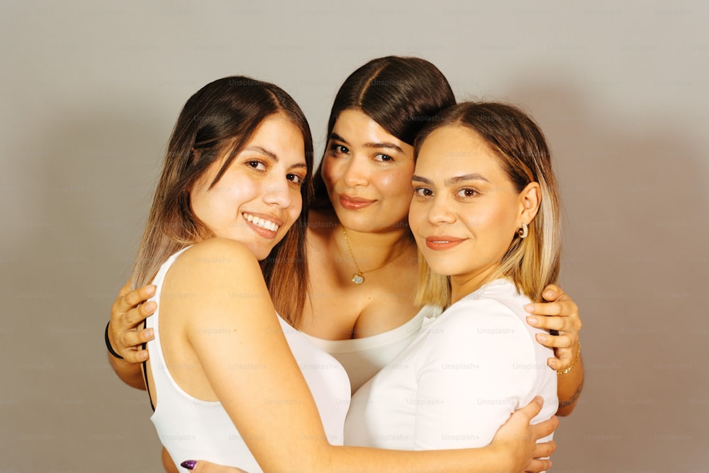 a group of three women hugging each other