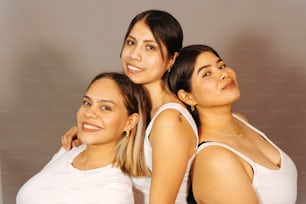 세 명의 여성이 함께 사진을 찍기 위해 포즈를 취하고 있다