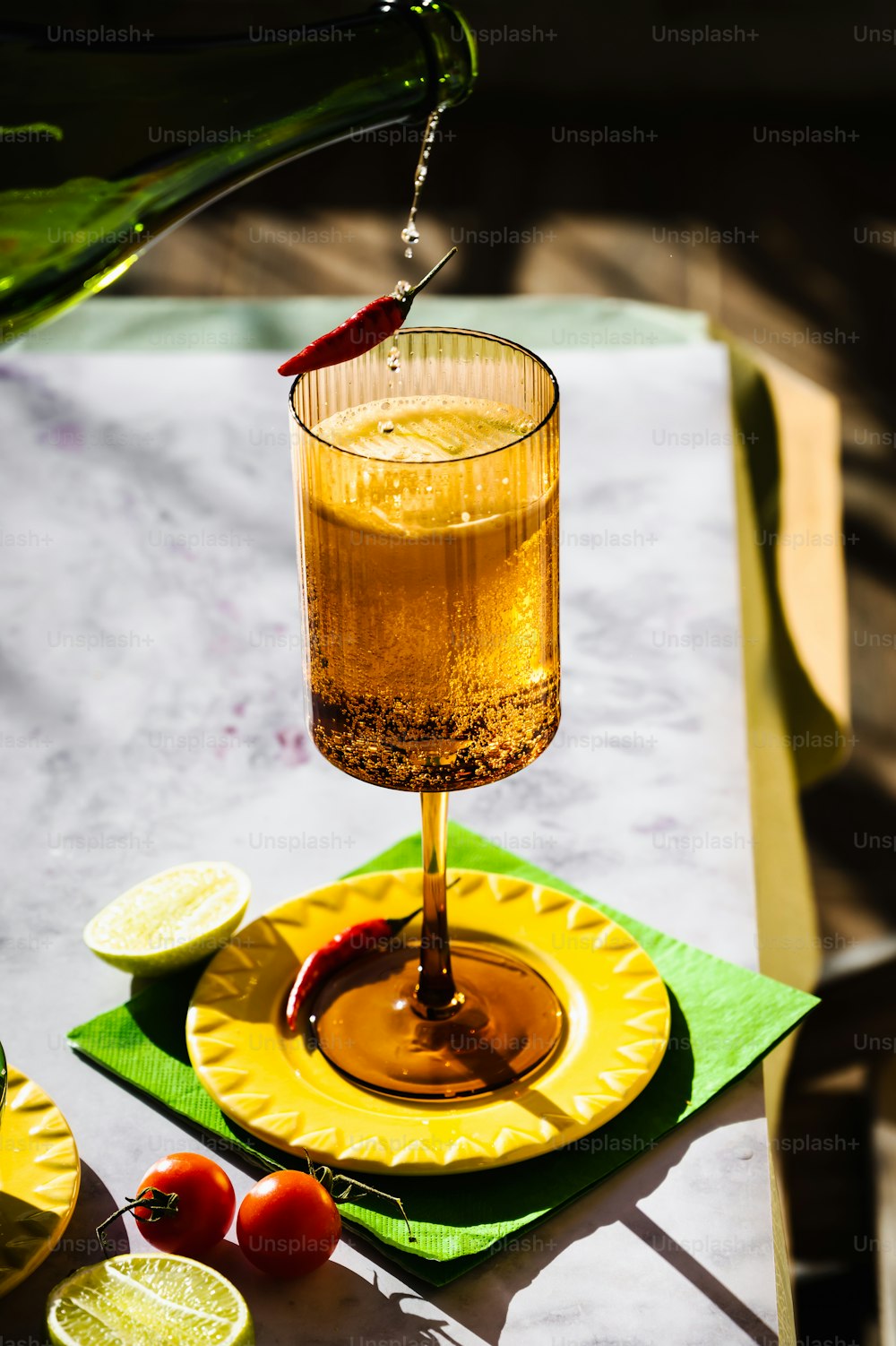 a drink being poured into a glass on a yellow plate