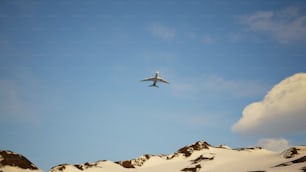 Un aeroplano che sorvola una montagna coperta di neve