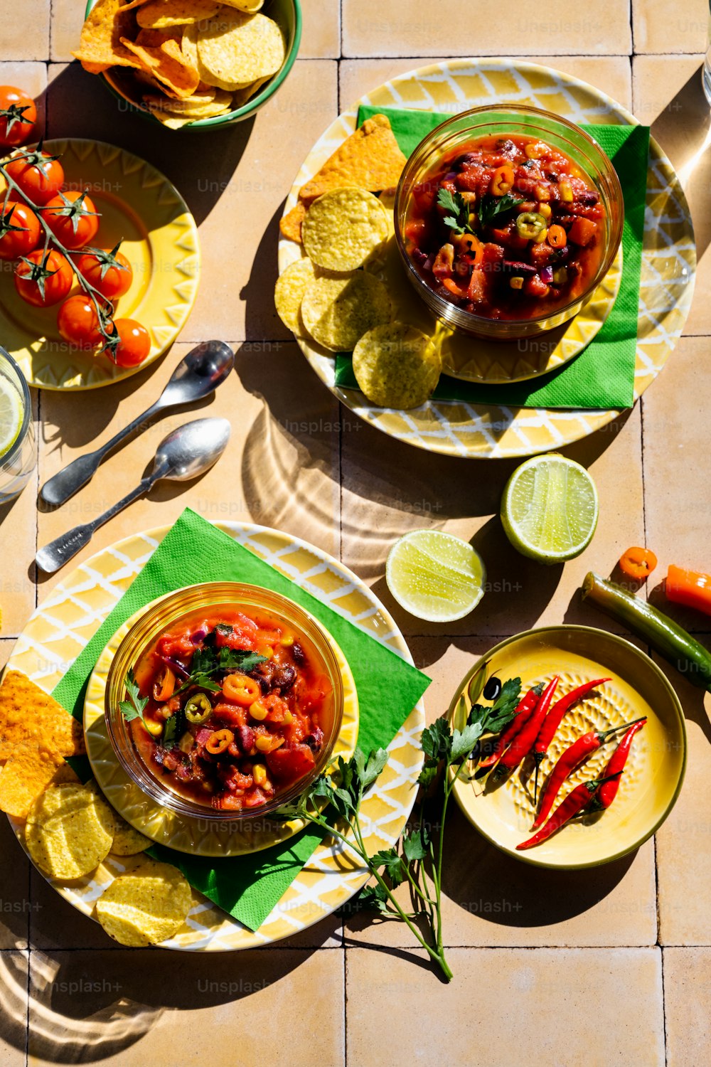 a table topped with plates of food and bowls of salsa
