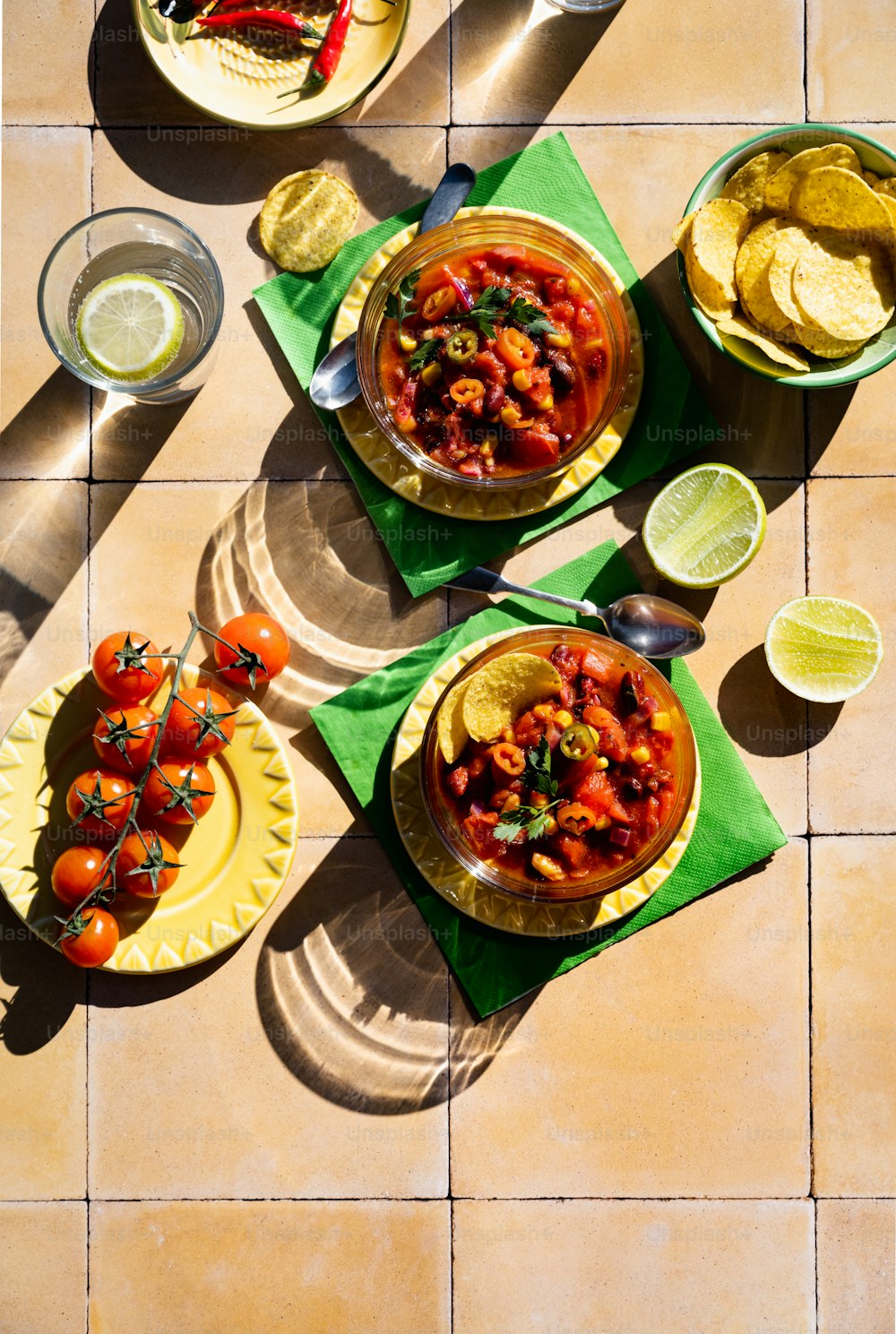 a table topped with plates of food and bowls of salsa