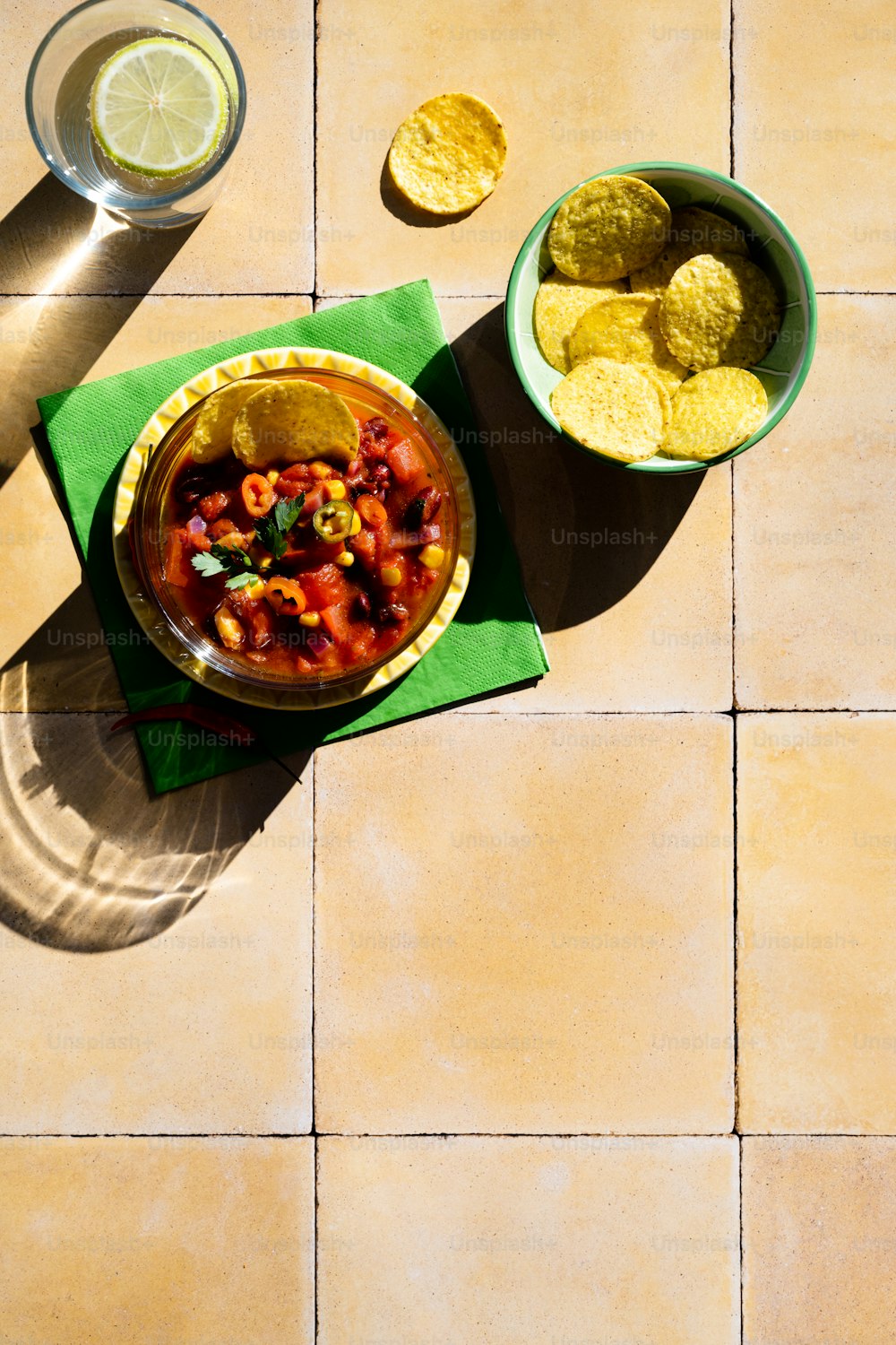 a bowl of salsa and a bowl of tortilla chips on a table