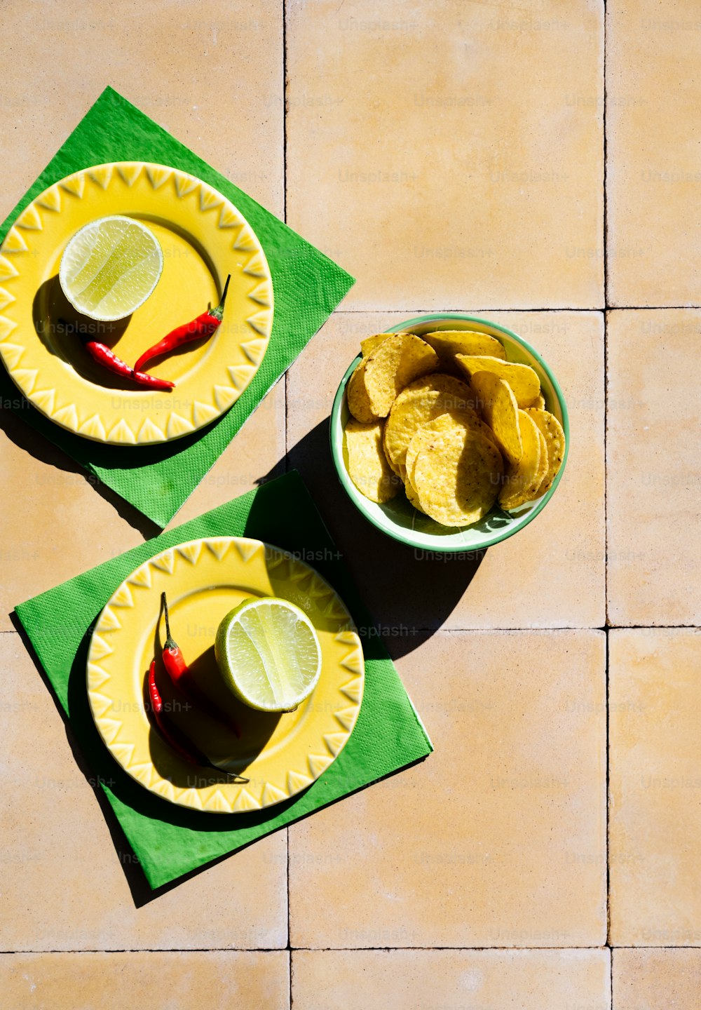 two bowls of chips and limes on a table