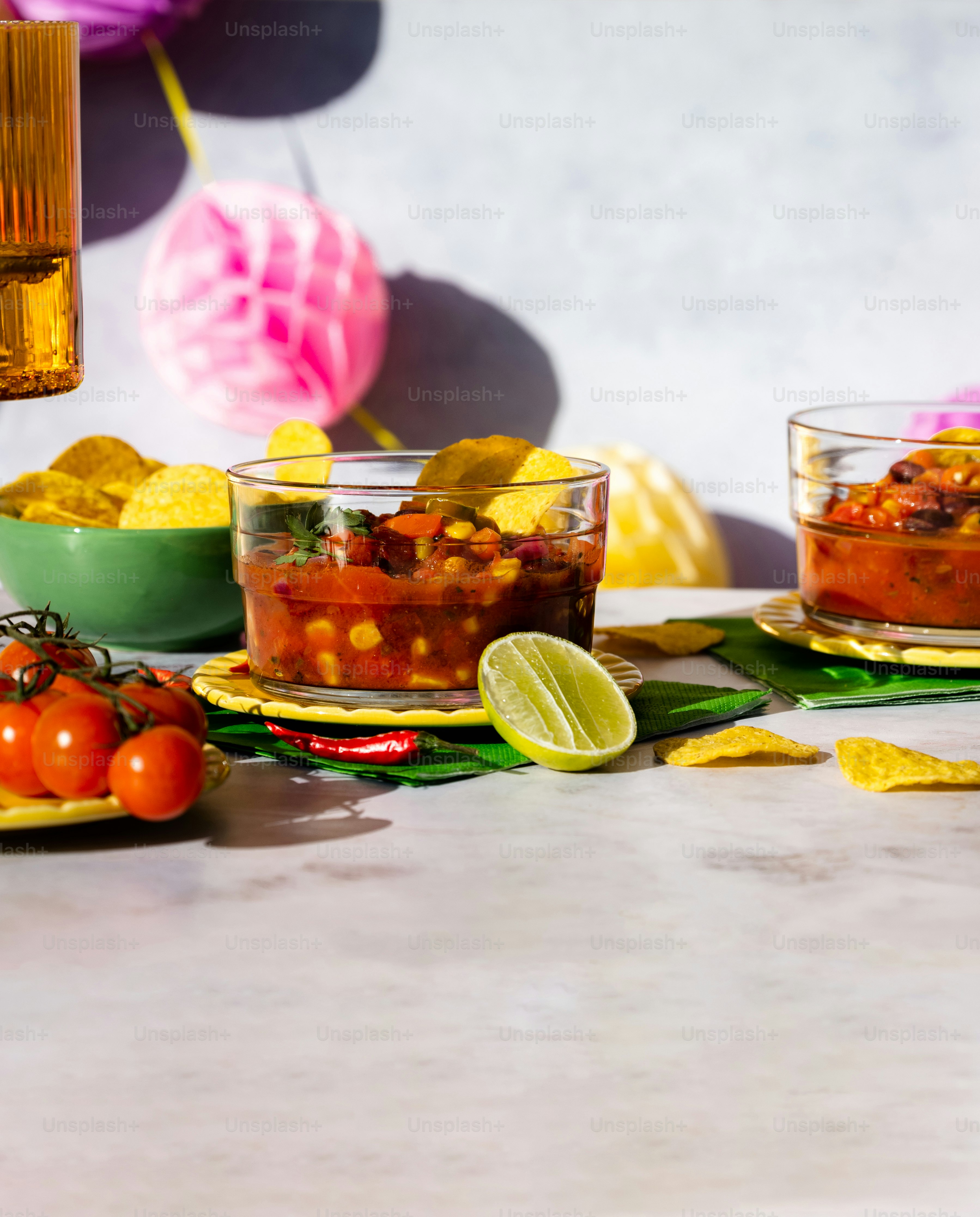 Una mesa cubierta con tazones de salsa y papas fritas