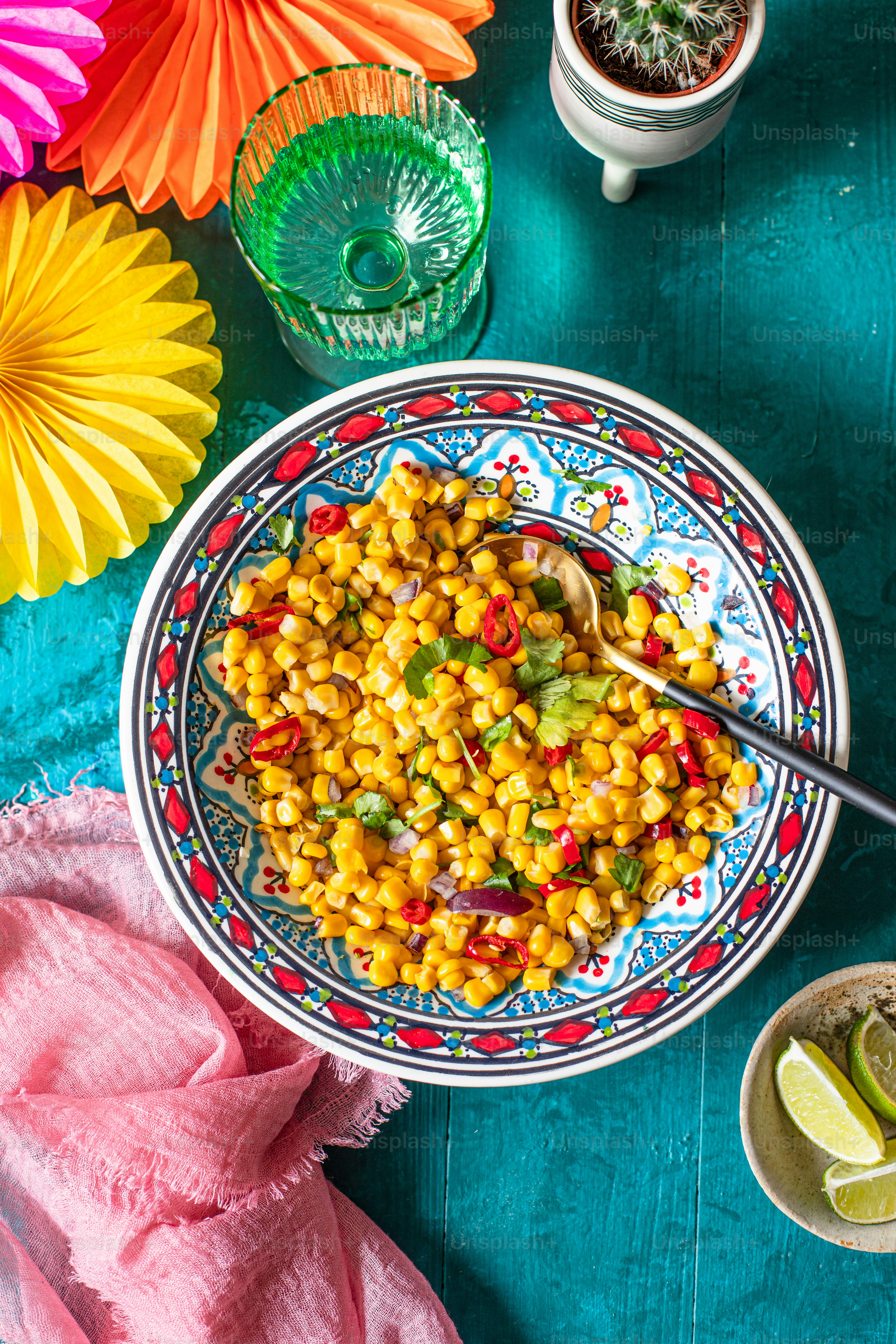 a bowl of corn with a spoon in it