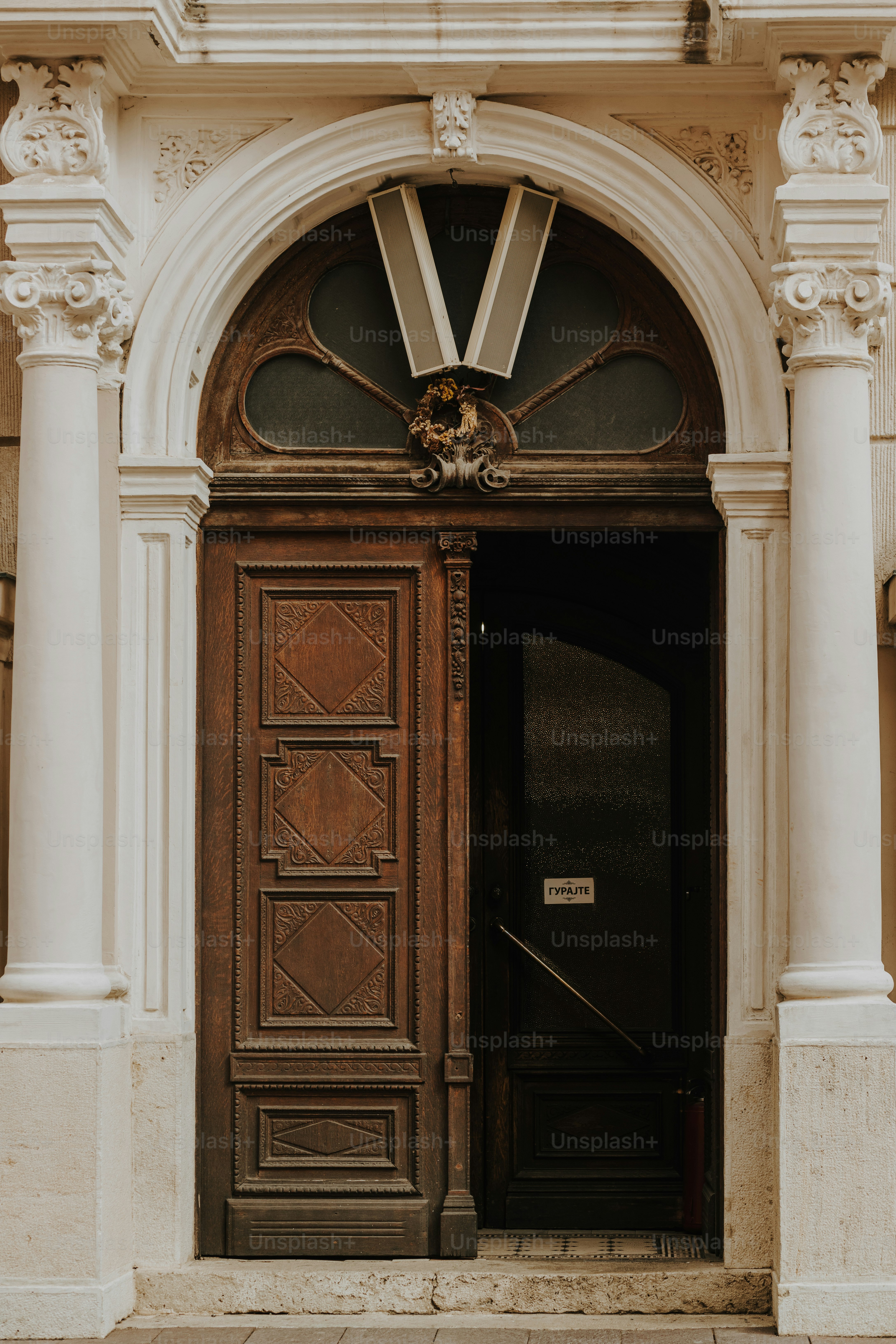 a large wooden door with a clock above it