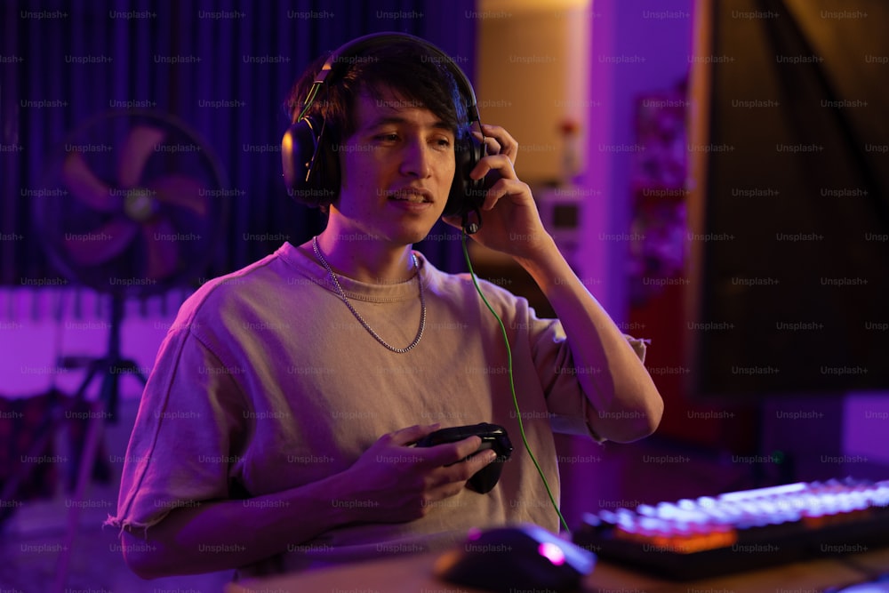 a man wearing headphones and holding a controller