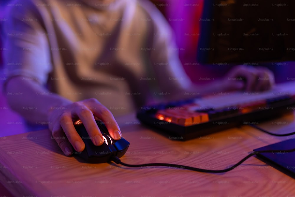 a person sitting at a desk with a mouse and keyboard