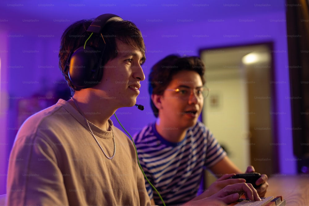 two young men are playing a video game