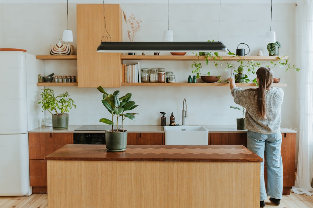 a woman standing in a kitchen next to a refrigerator