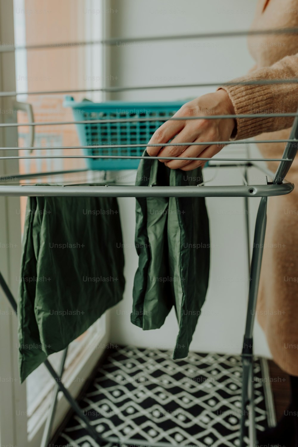a woman is holding a green coat on a clothes rack