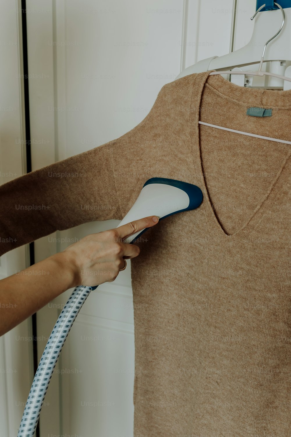 une personne utilisant un sèche-cheveux pour sécher un T-shirt
