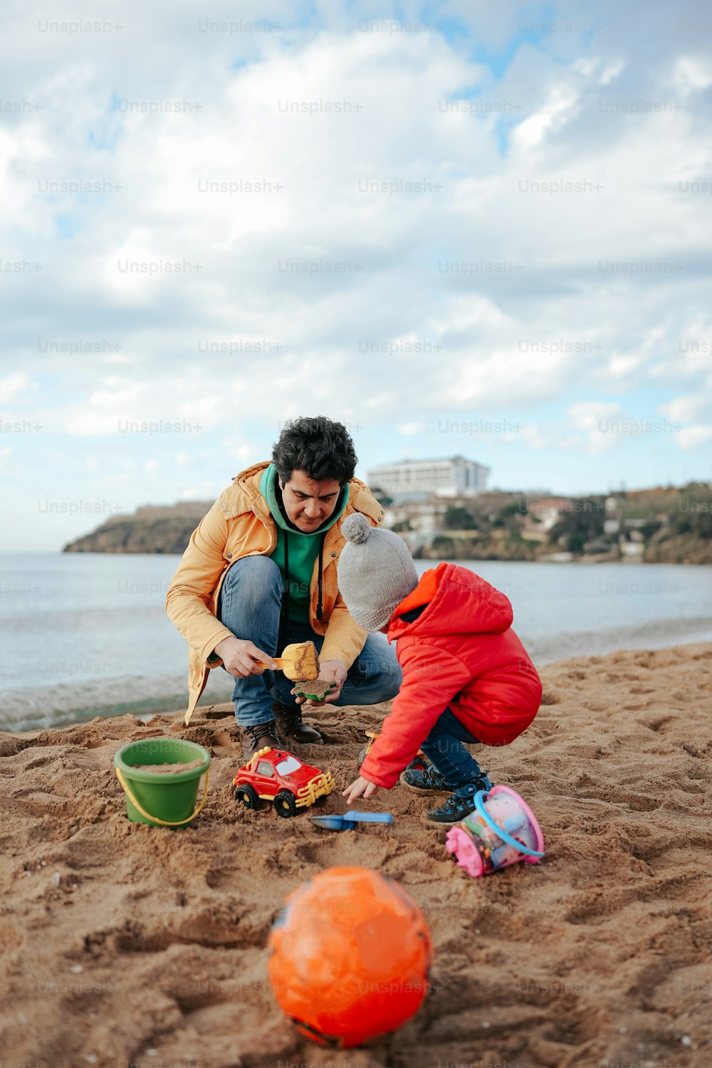 Un uomo e un bambino che giocano nella sabbia della spiaggia