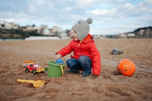 a young child playing in the sand on the beach