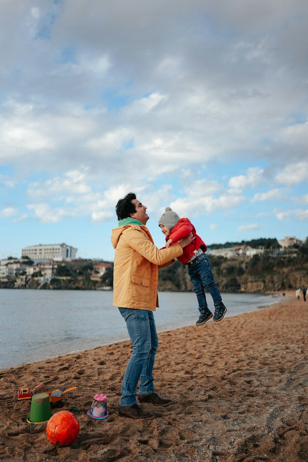 a man holding a child on the beach