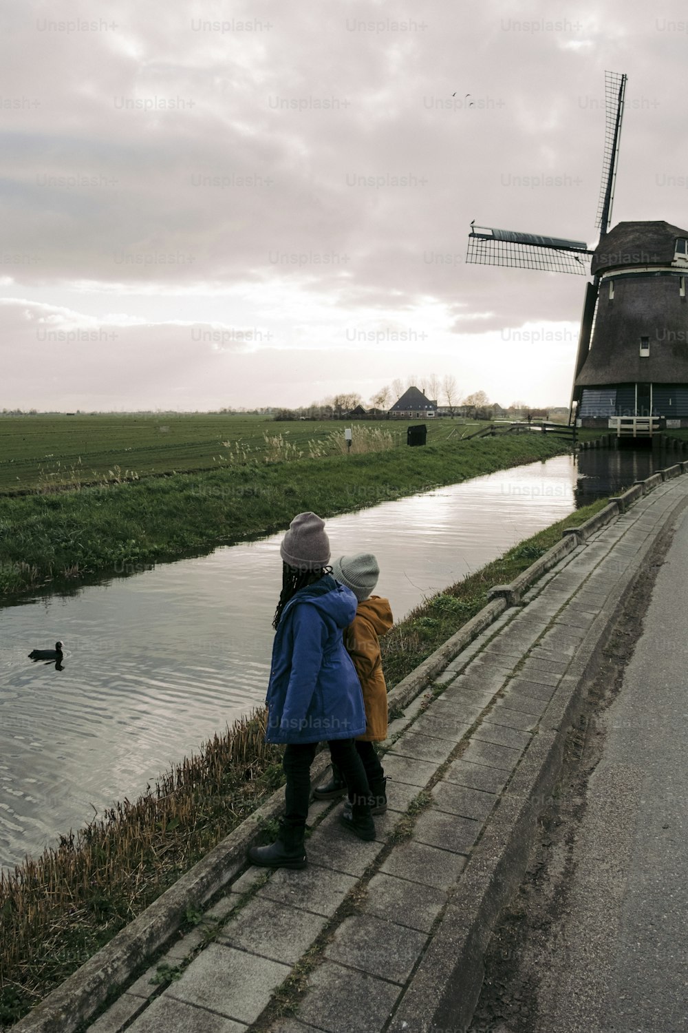 a couple of people standing next to a body of water