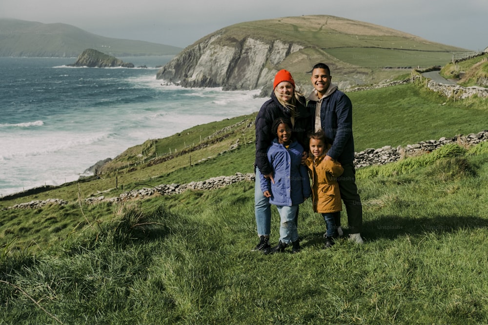 a group of people standing on top of a lush green hillside