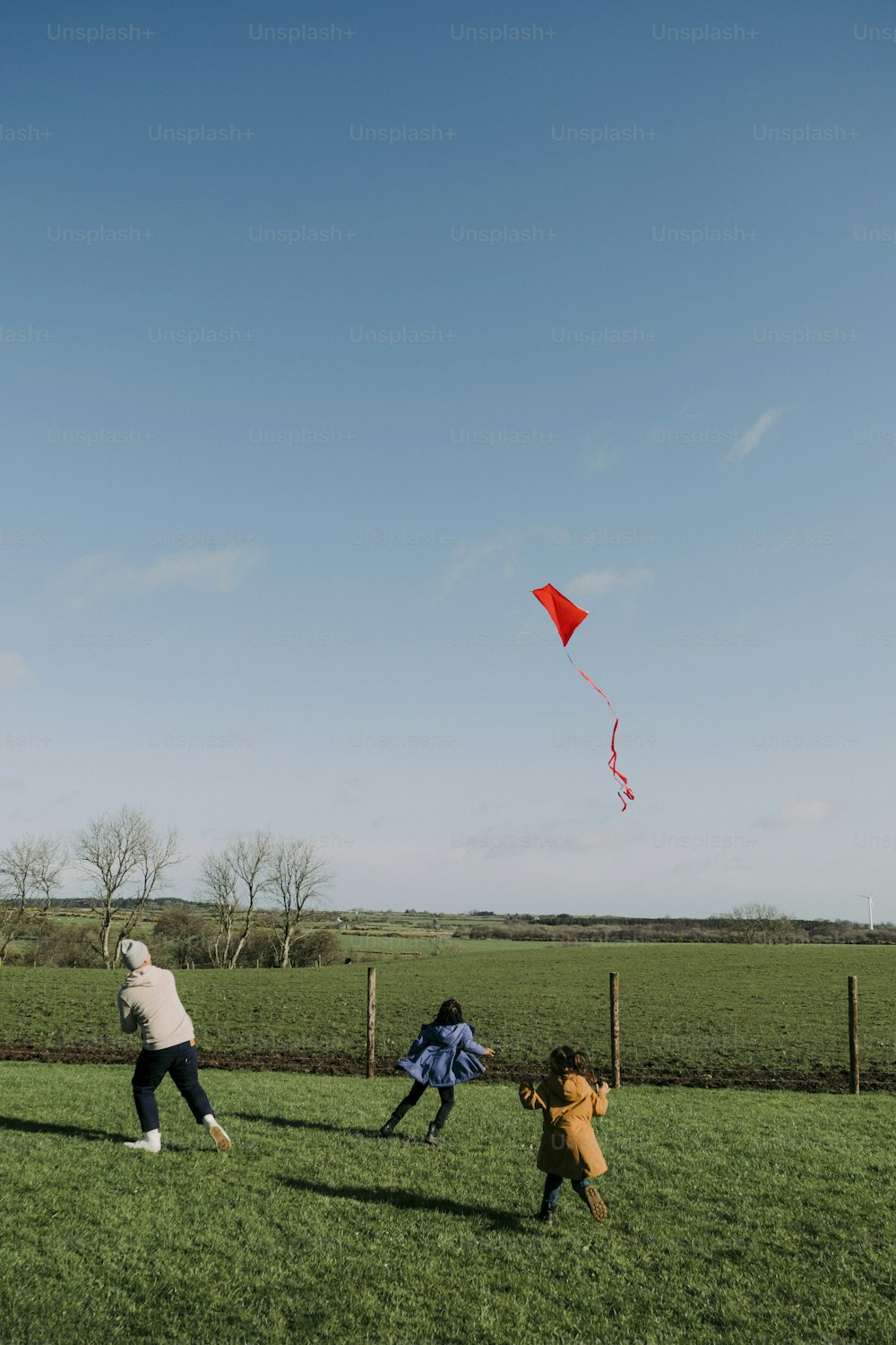 Un grupo de personas en un campo volando una cometa