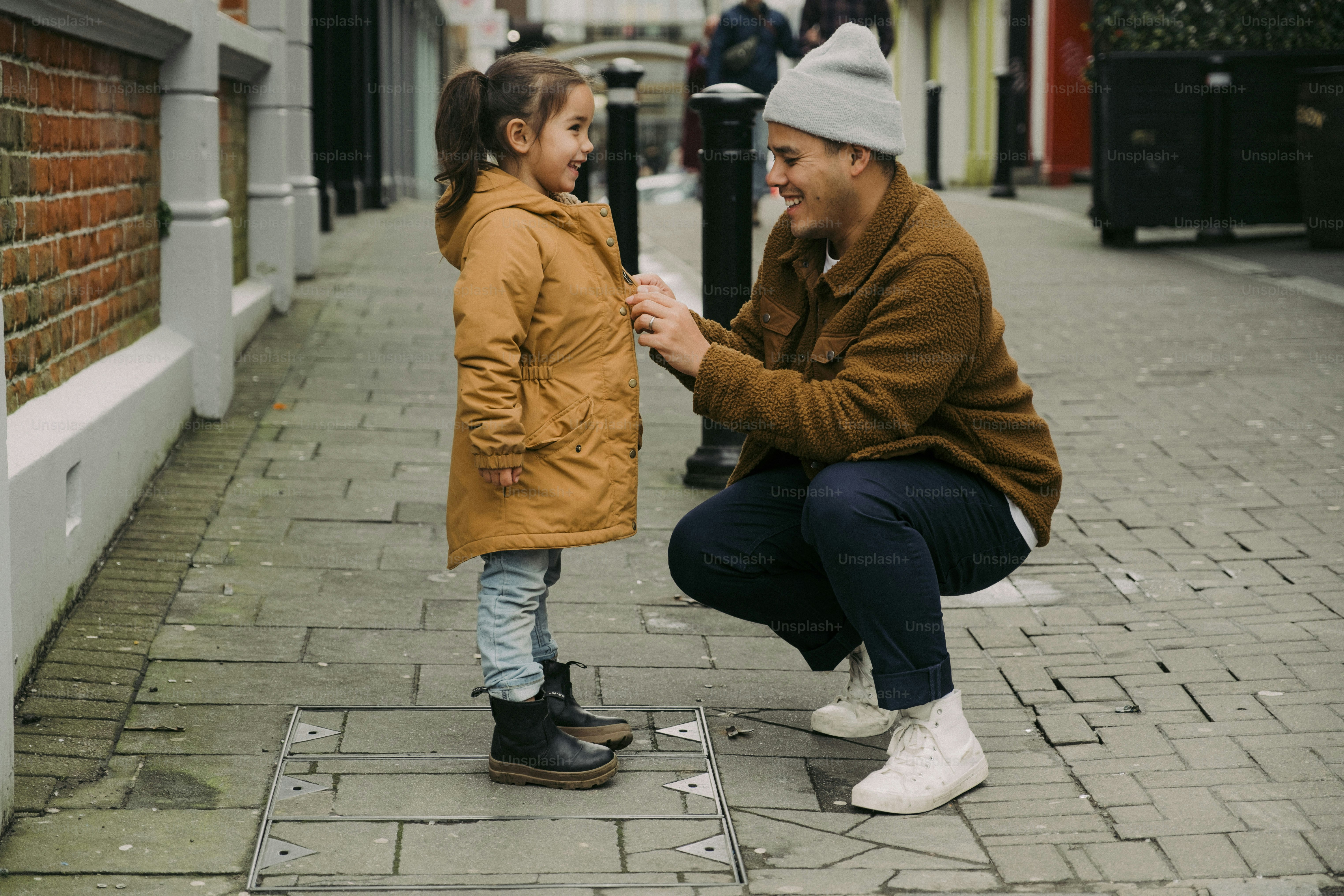 a man kneeling down next to a little girl