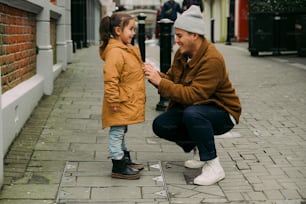 Un uomo inginocchiato accanto a una bambina