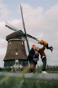 three people standing in front of a windmill
