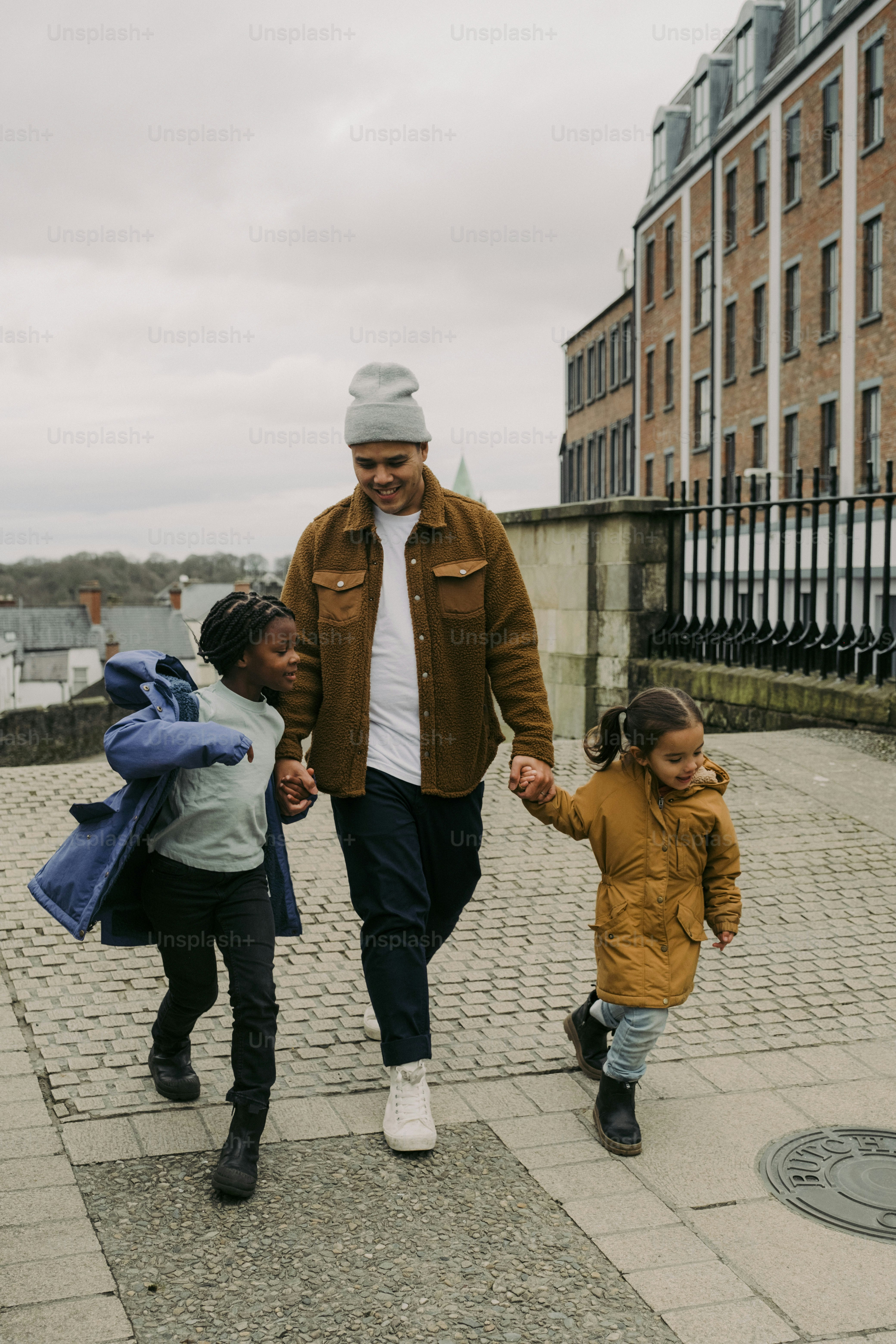 a man and two children walking down a sidewalk