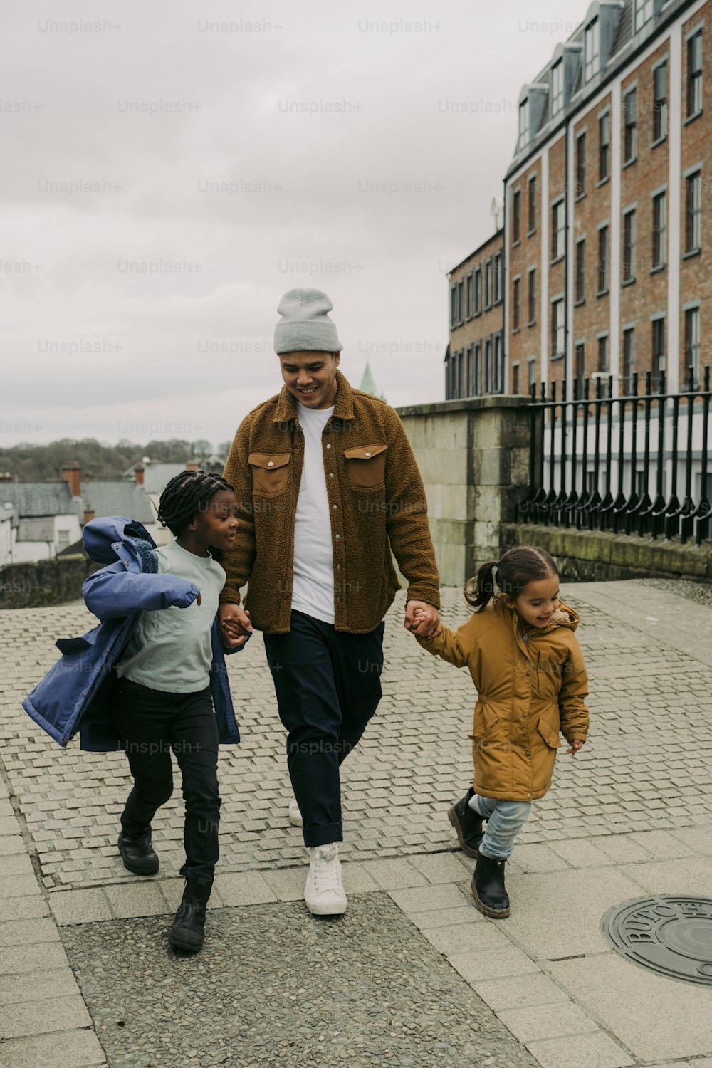 a man and two children walking down a sidewalk