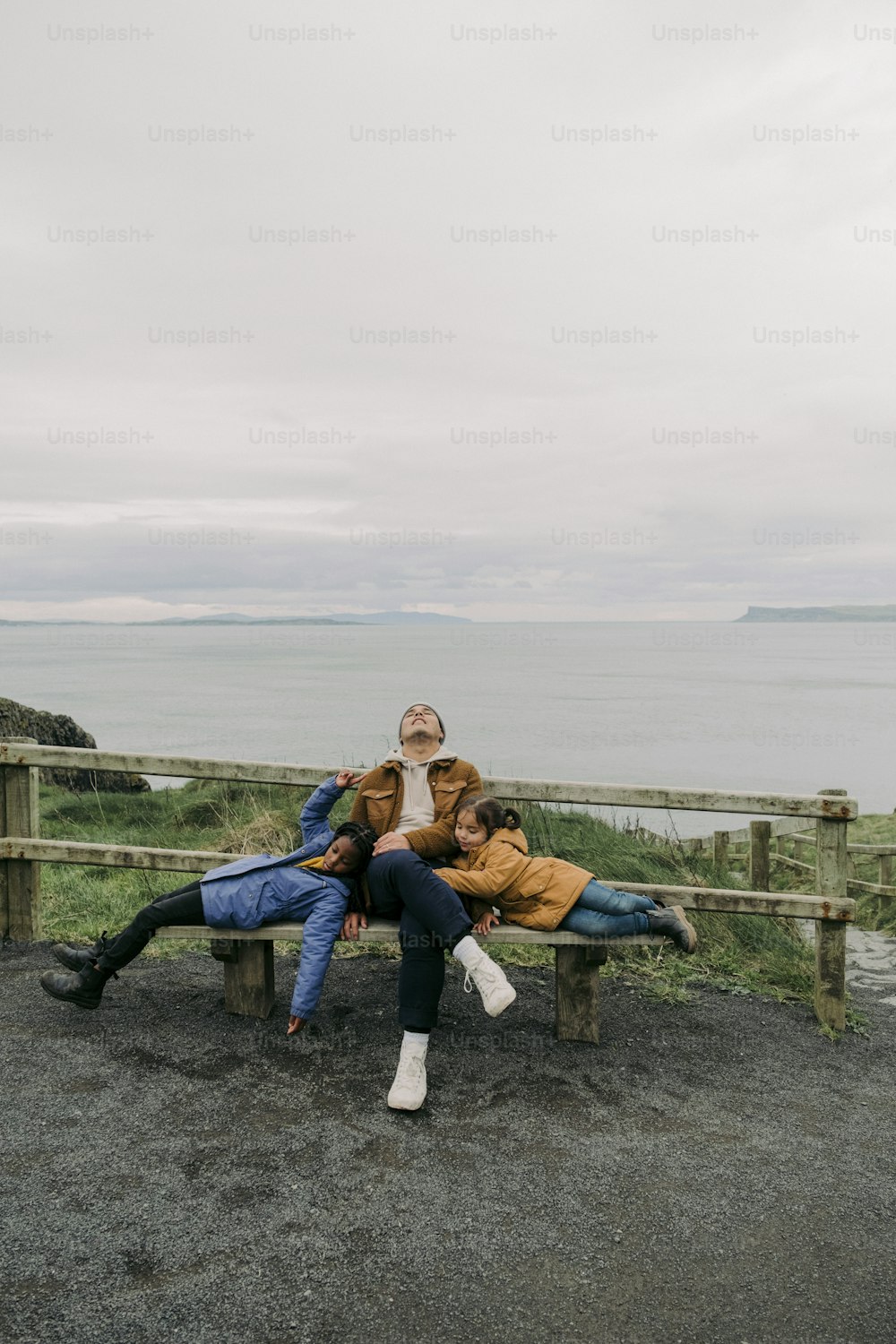Zwei Personen sitzen auf einer Bank in der Nähe des Ozeans