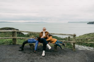 a couple of people sitting on top of a wooden bench