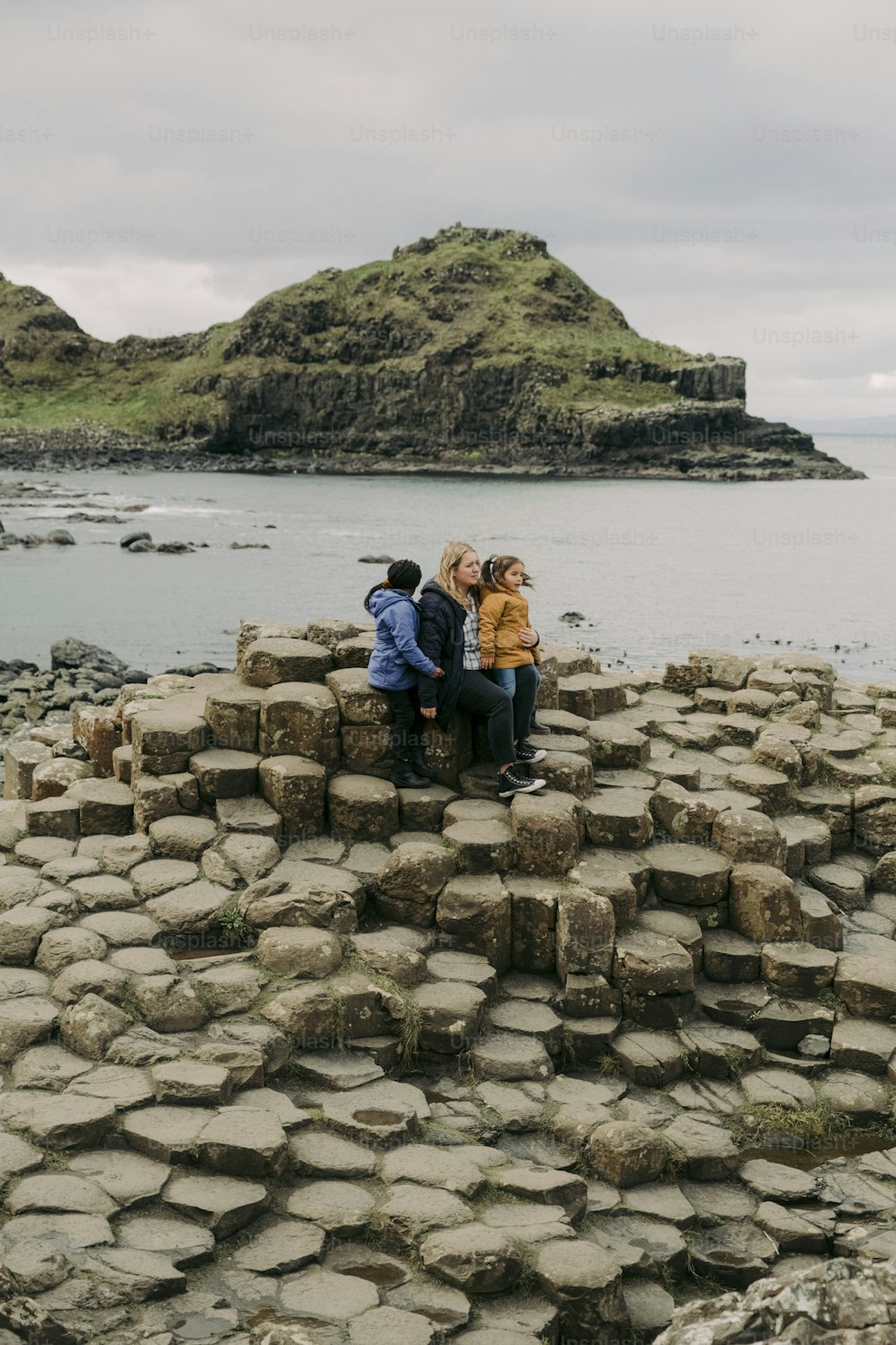 a group of people sitting on top of a rock formation