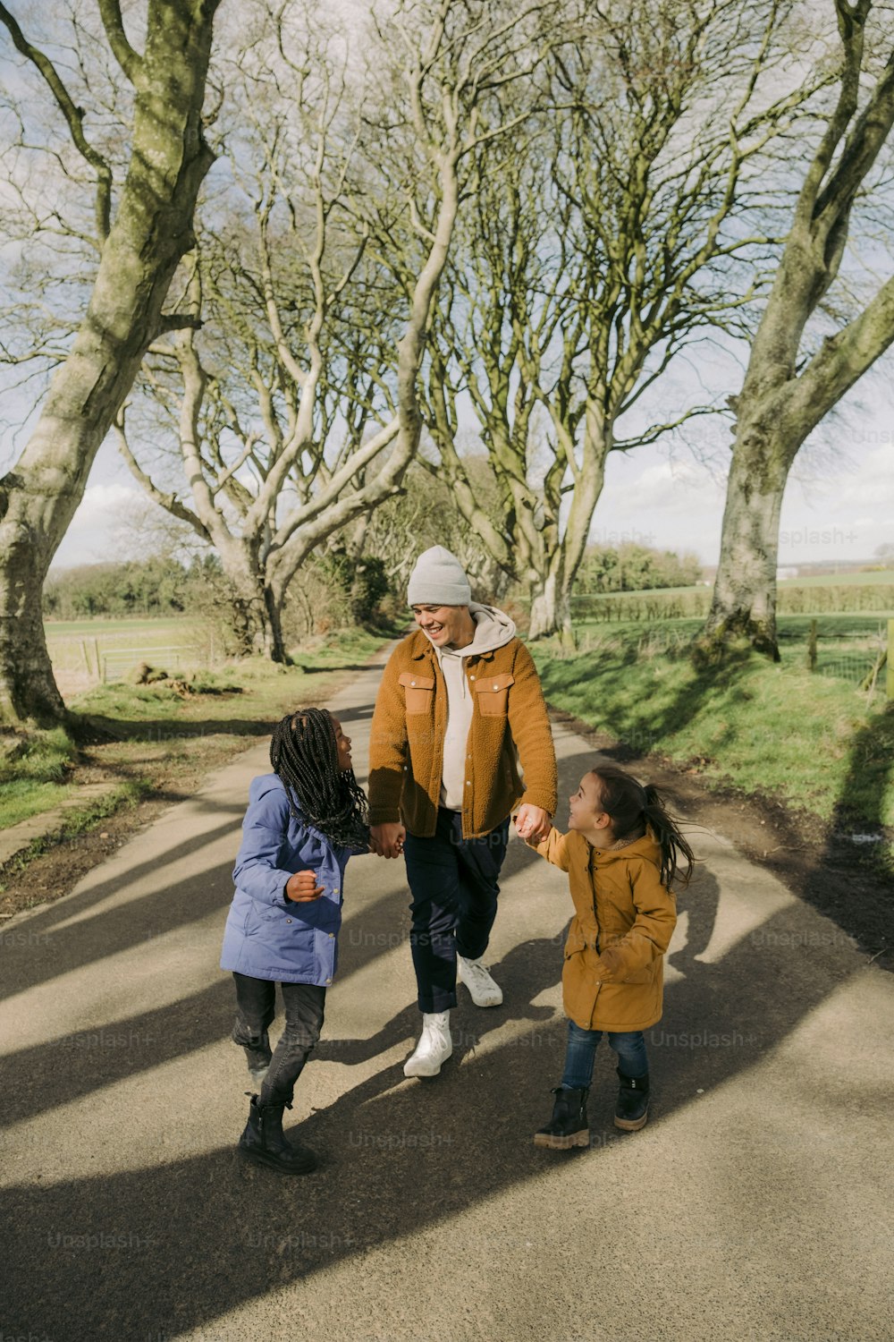 a man and two children walking down a road