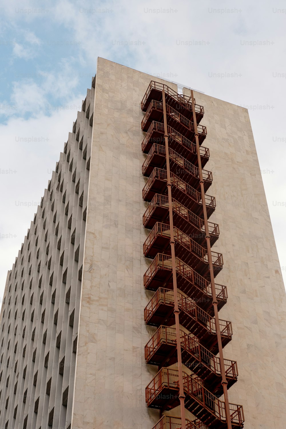 Un edificio alto con una escalera de incendios a un lado