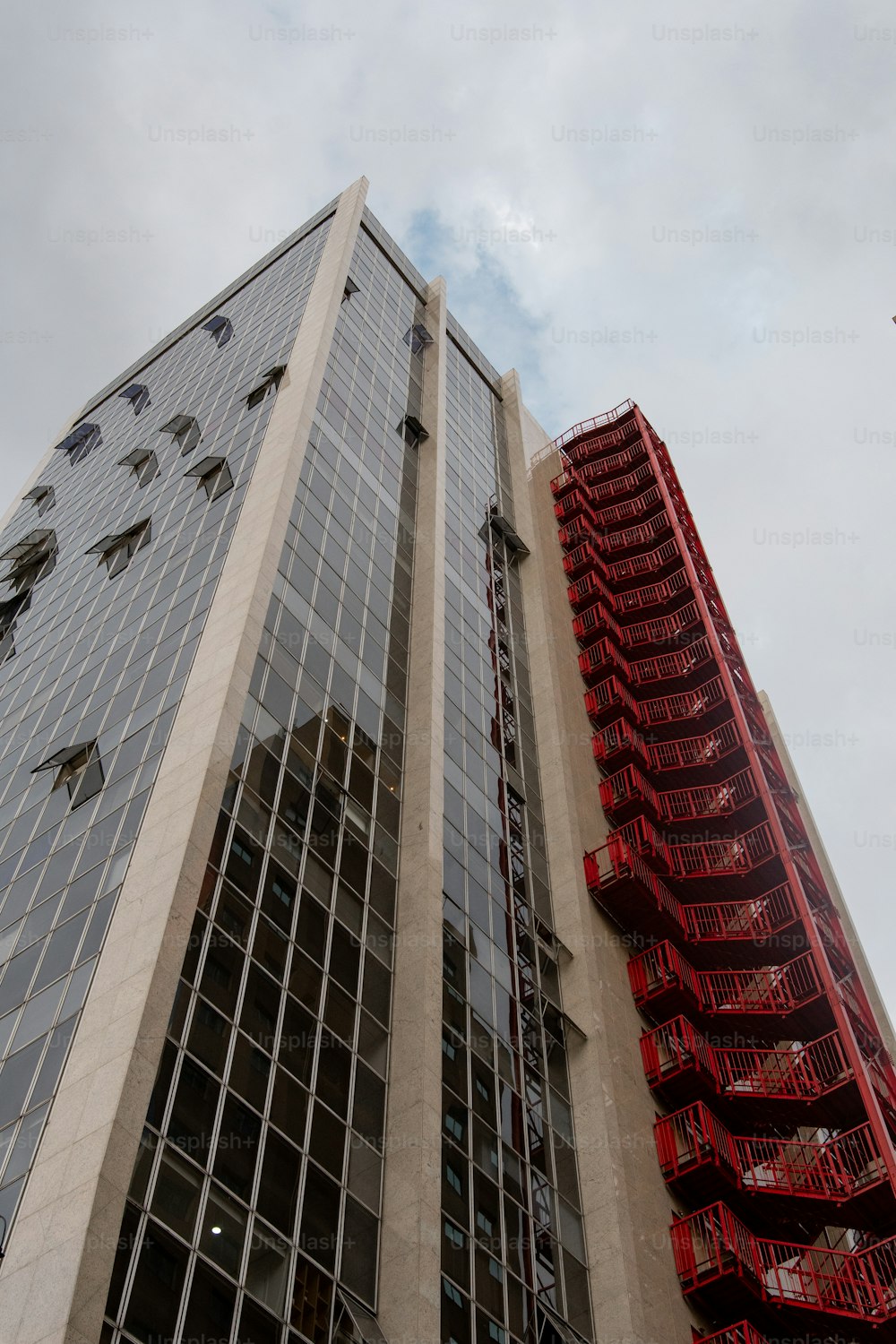 Un edificio muy alto con una escalera de incendios roja