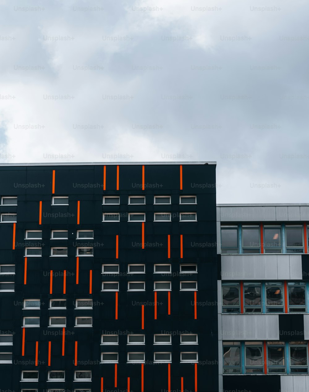 Un edificio negro con tiras naranjas en el costado