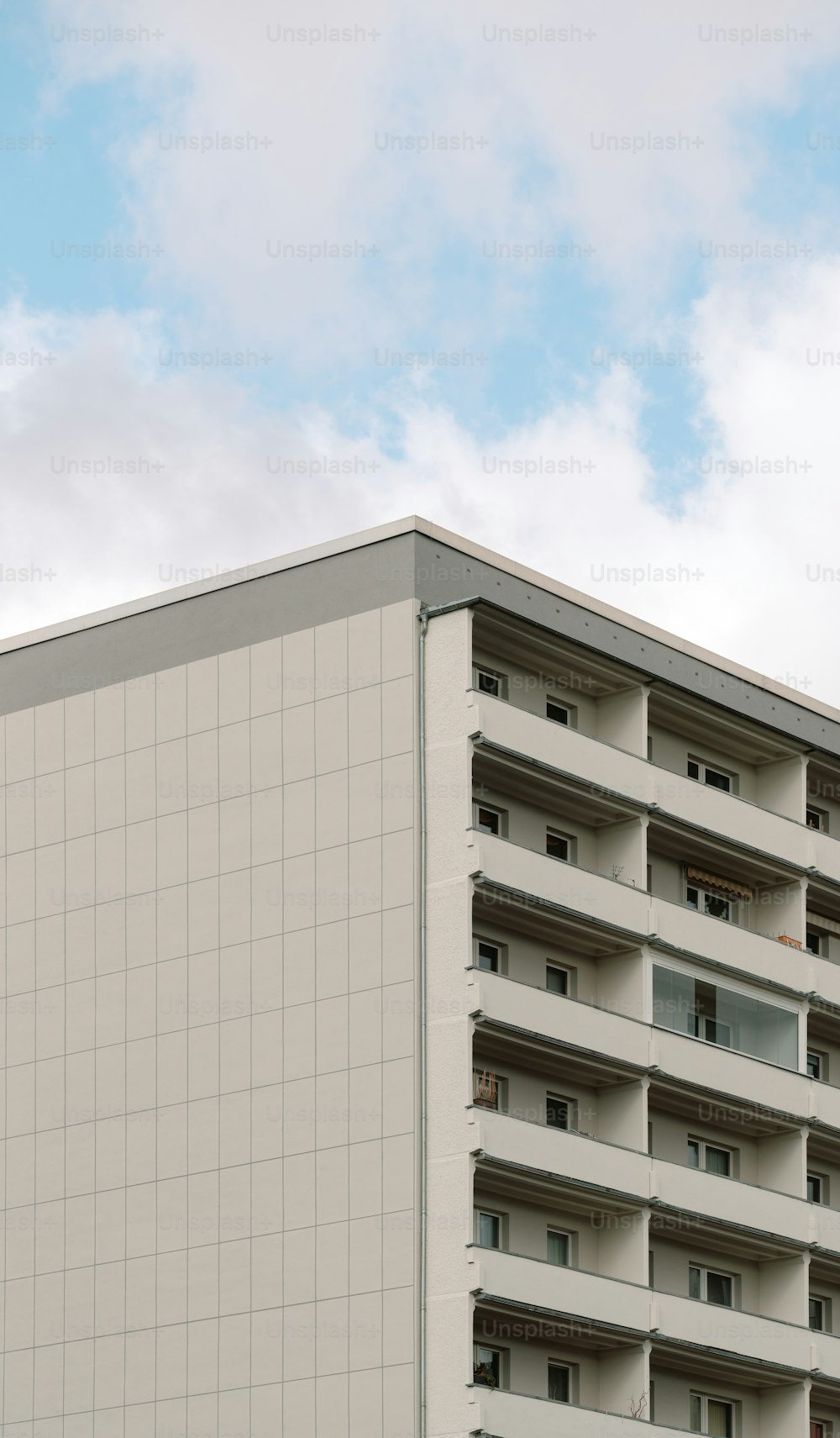 a tall white building sitting next to a parking meter