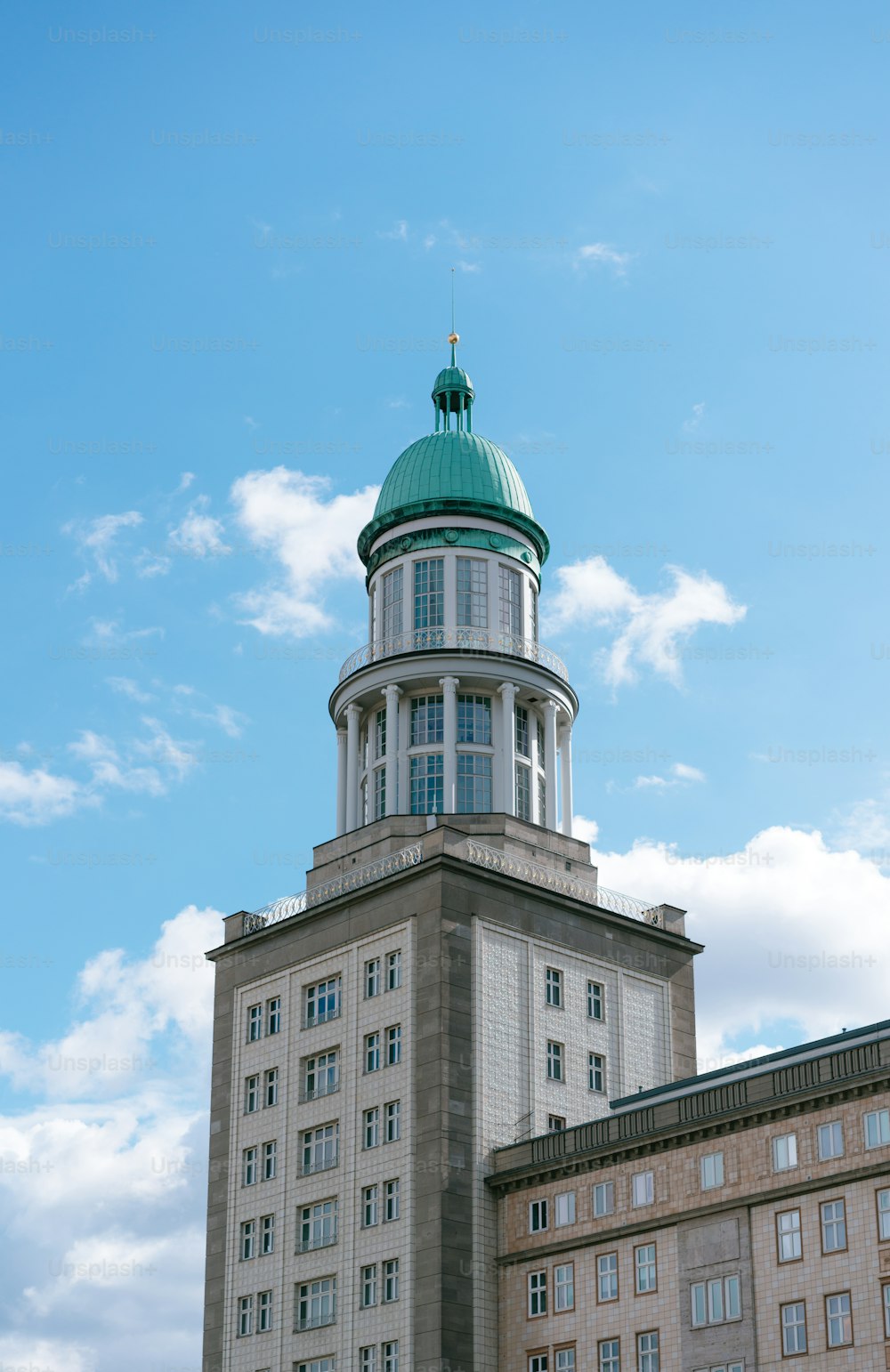 a tall building with a green dome on top