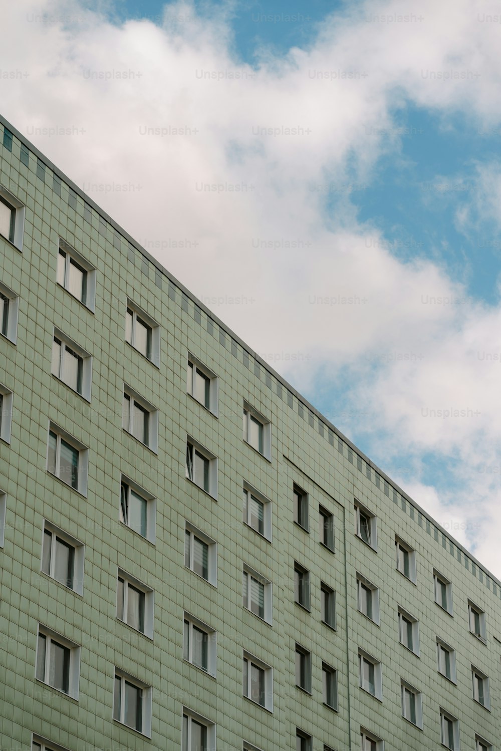 a tall building with many windows and a clock on the side of it