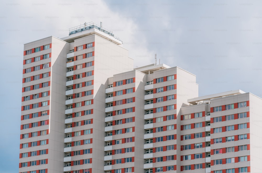 Un edificio alto con ventanas rojas y blancas