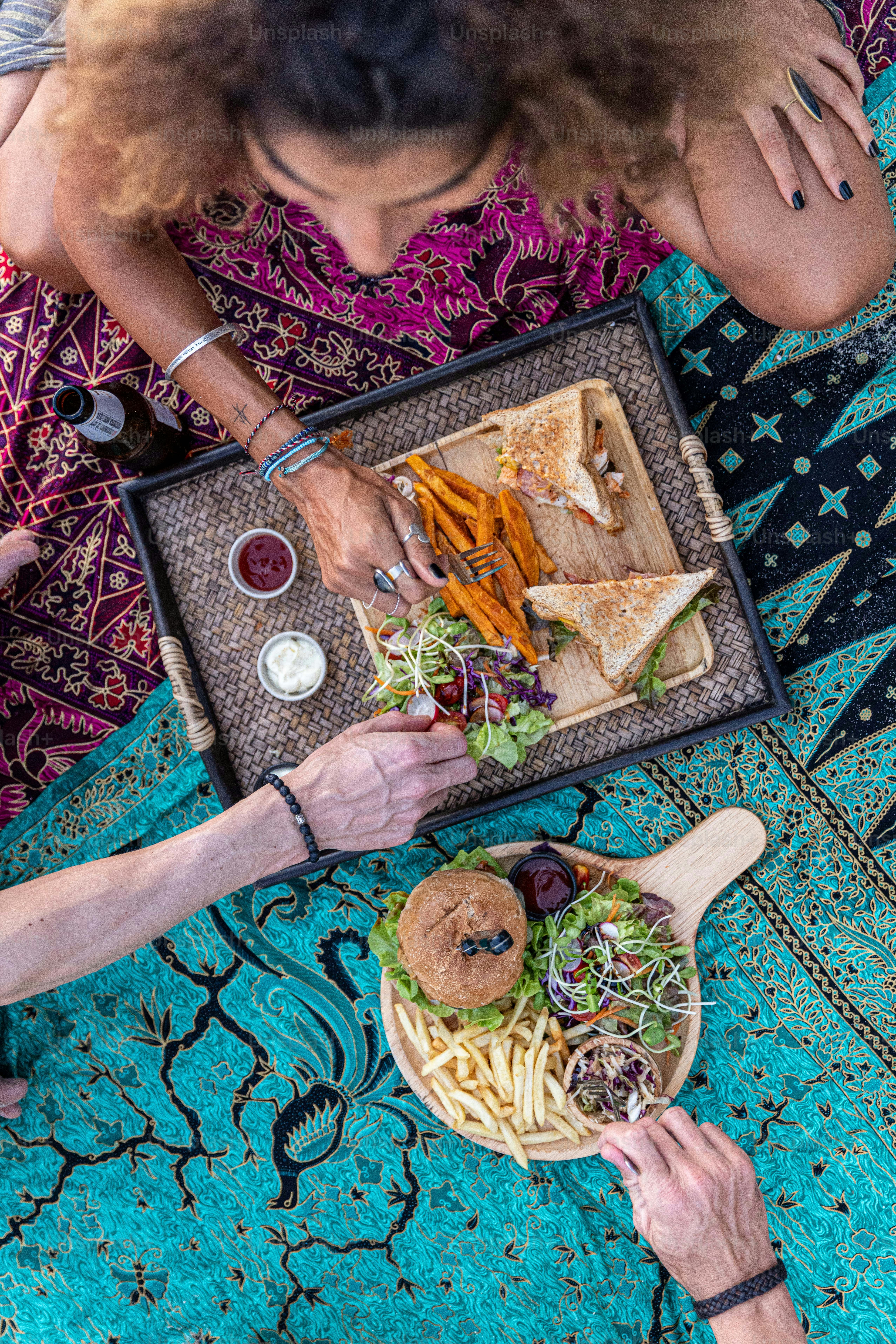 A group of people sitting around a table eating food photo Food Image