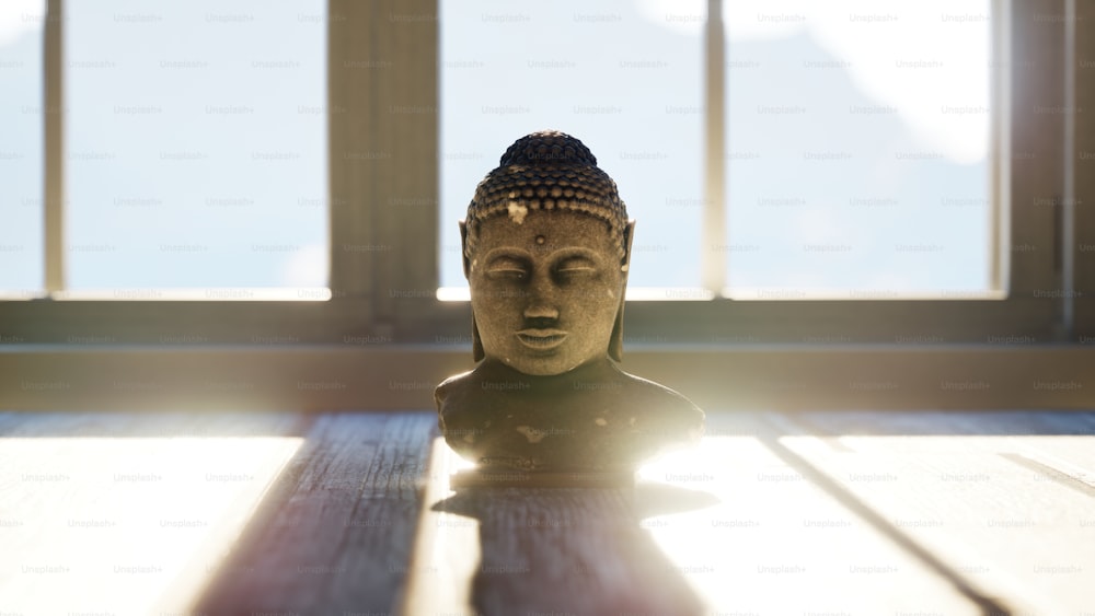 uma estátua de buddha sentada em cima de uma mesa de madeira