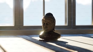 uma estátua de buddha sentada em cima de uma mesa de madeira