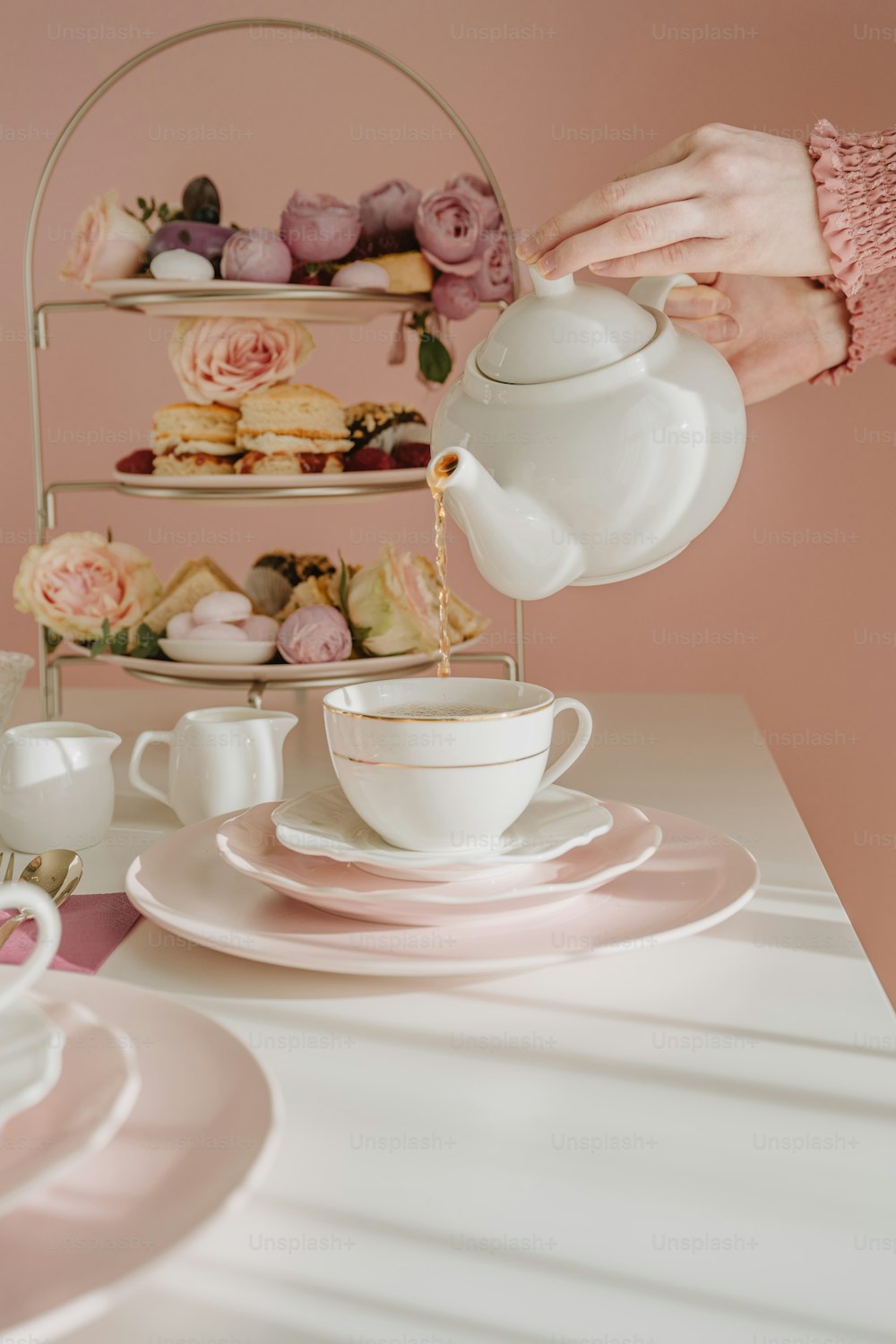 a person pouring tea into a cup on a table