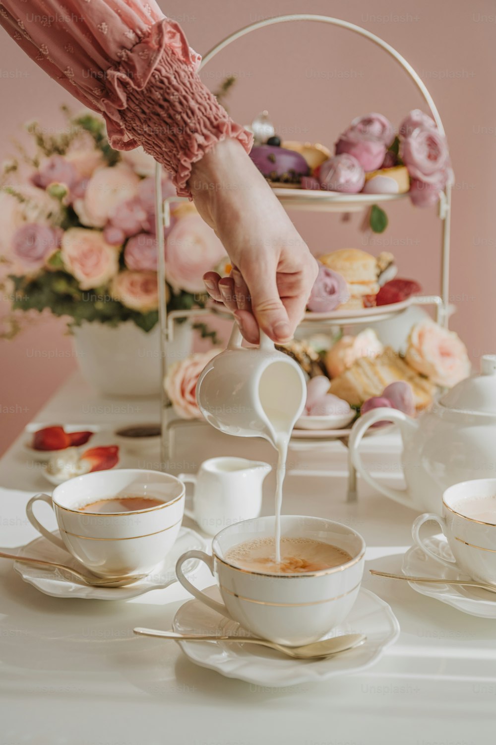 a person pouring milk into a cup of coffee