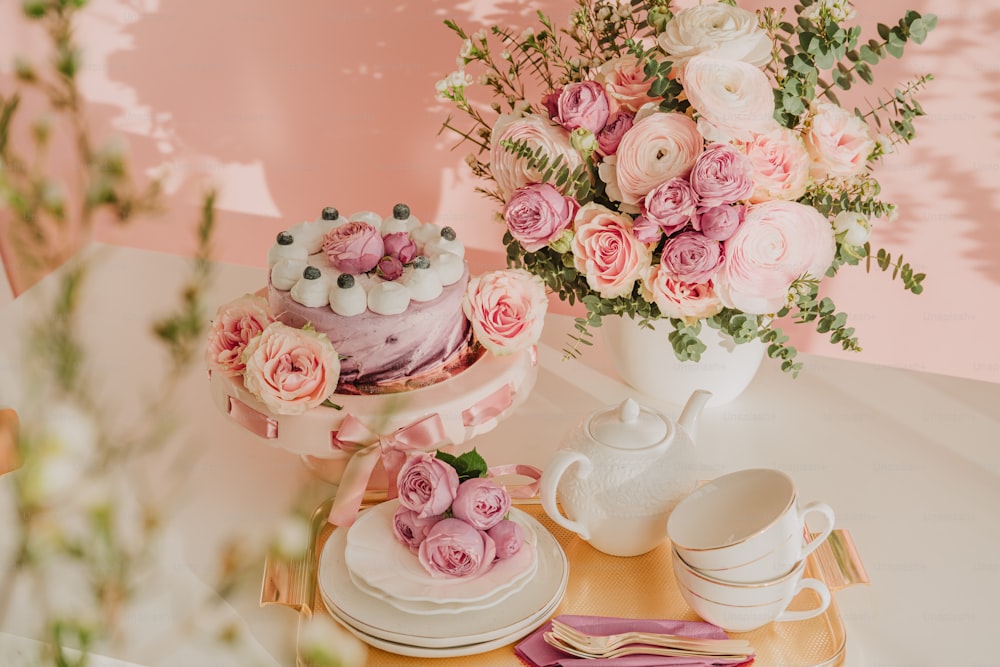 꽃으로 가득 찬 꽃병 옆에 케이크를 얹�은 테이블