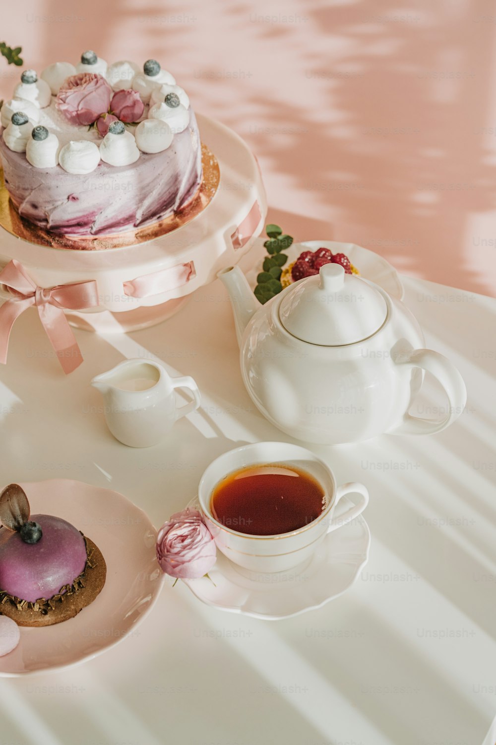 a table topped with a cake next to a cup of tea