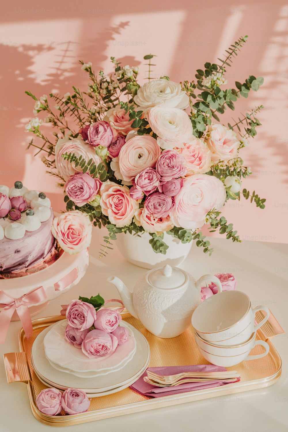 ケーキと花でいっぱいの花瓶をトッピングしたテーブル