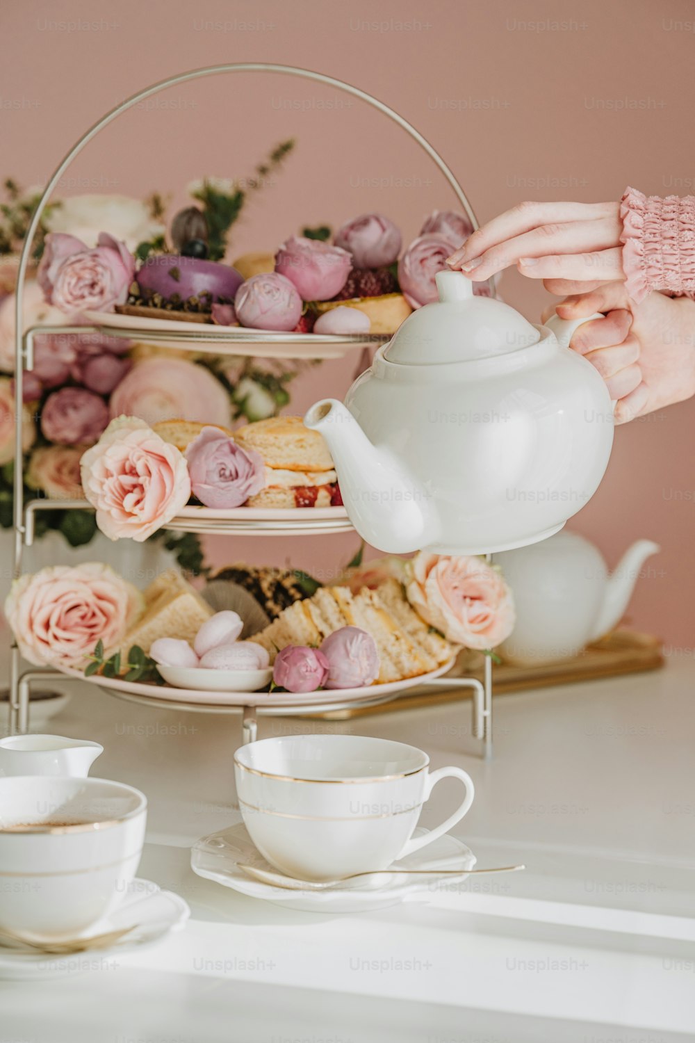 a person pouring a cup of tea from a teapot