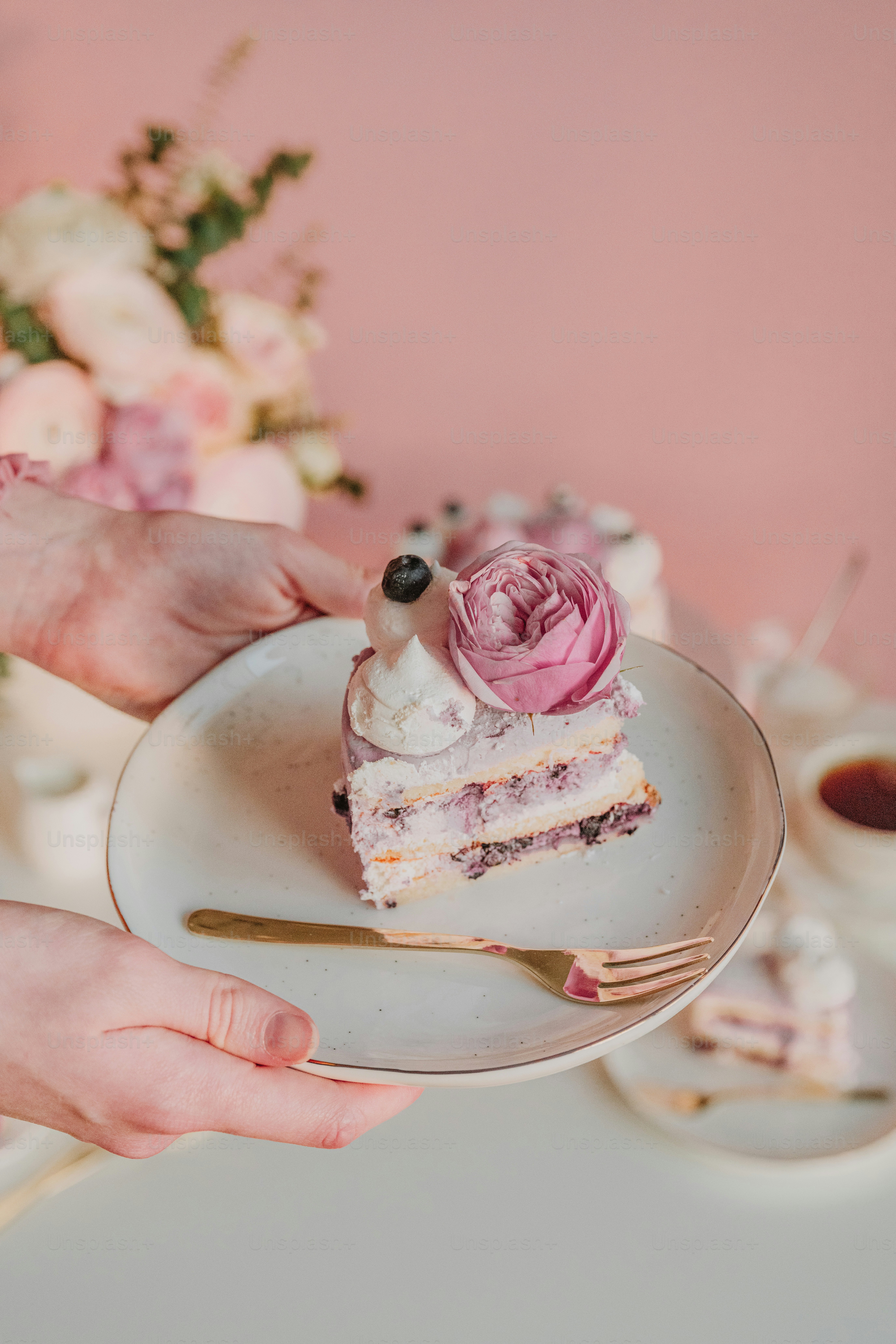 a person holding a plate with a piece of cake on it