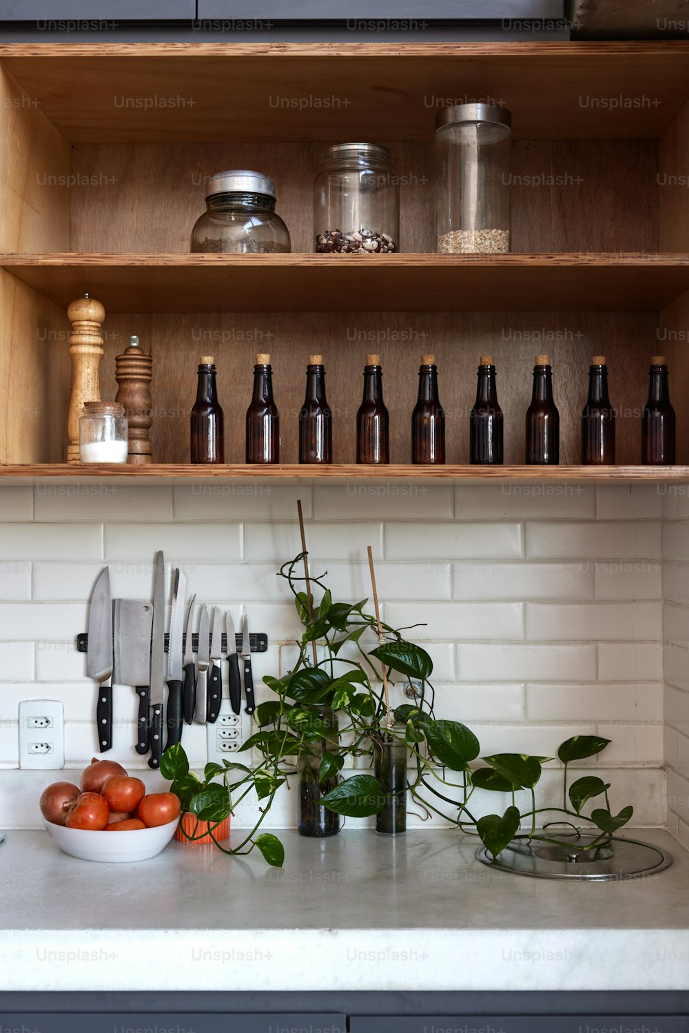 um balcão de cozinha coberto com muitas garrafas e legumes